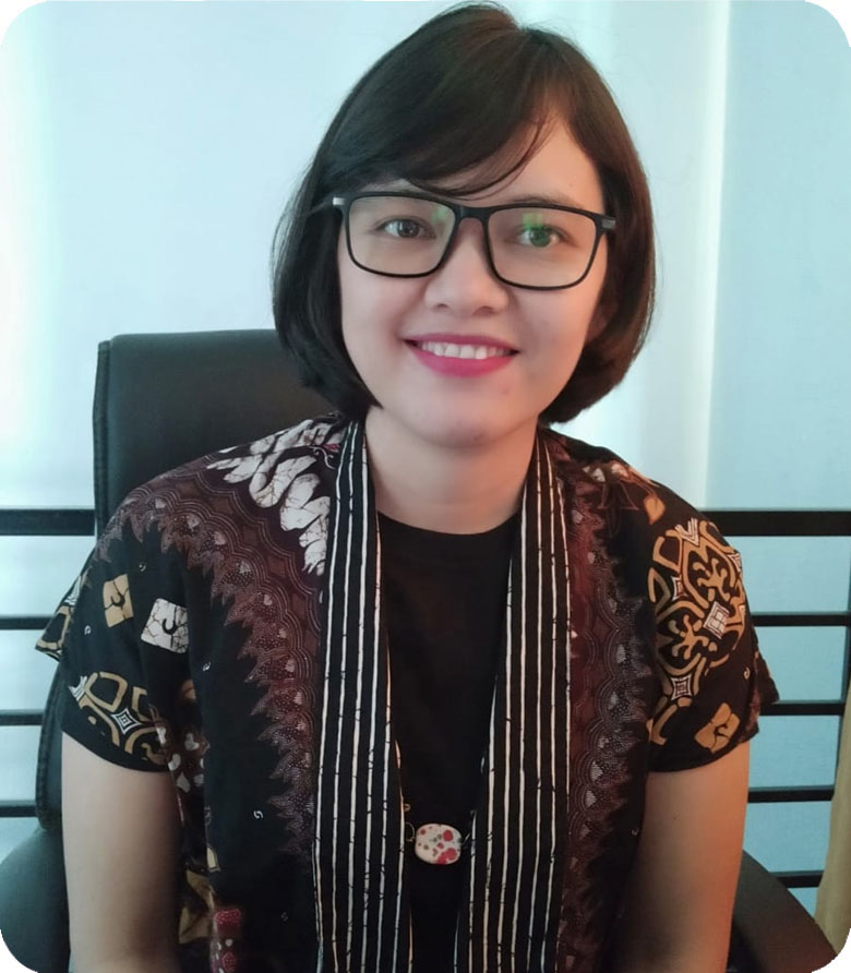 Artiwinata Ginting - Psikolog pria berusia 35-an mengenakan jas formal, tersenyum percaya diri dengan sertifikat psikologi di dinding belakang